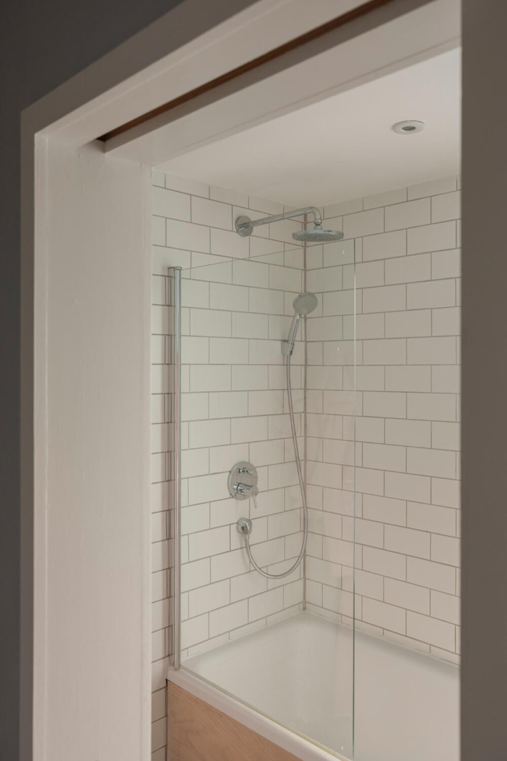 bathroom combined shower bath white tiles