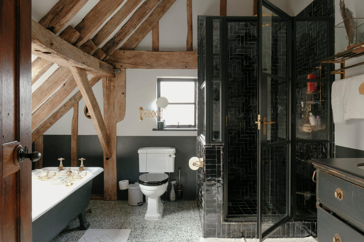 bathroom slanted ceiling with wooden beams and black tiles
