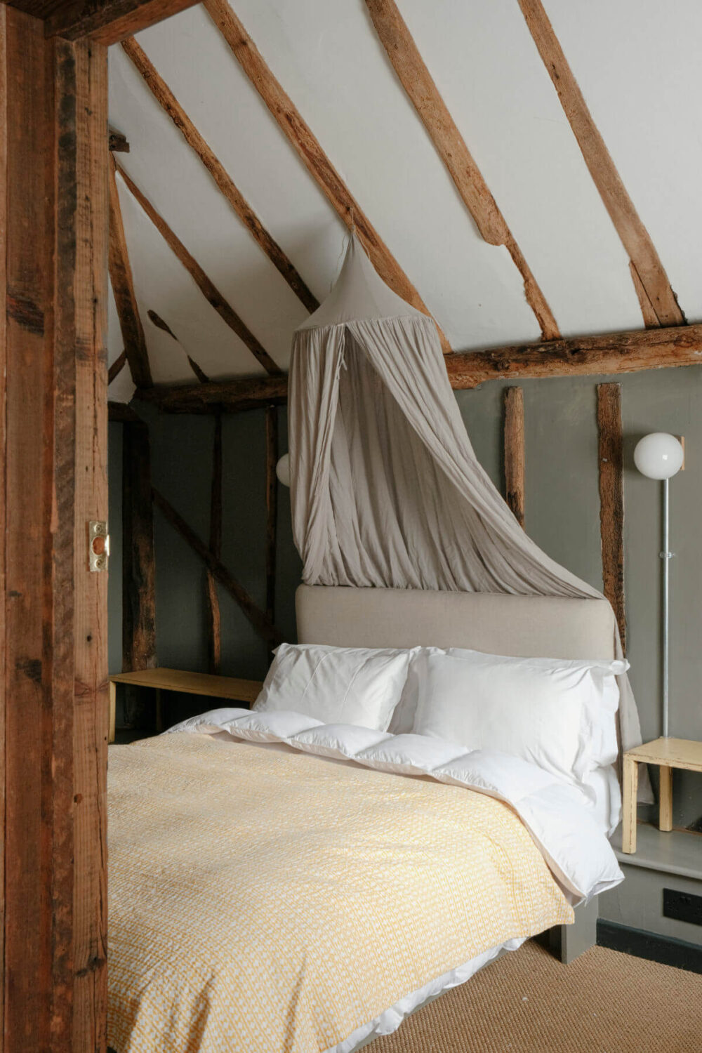 bedroom with canopy and pitched ceiling with wooden beams