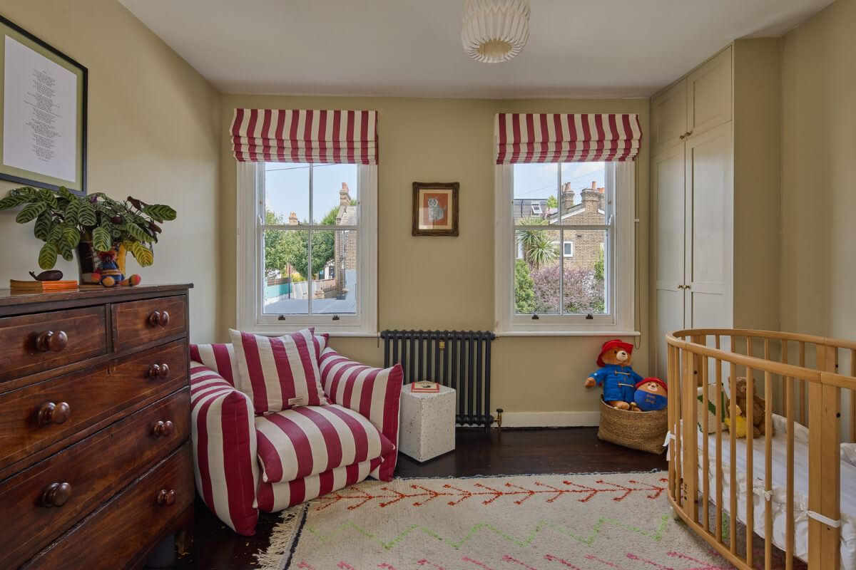beige nursery red striped chair and curtains