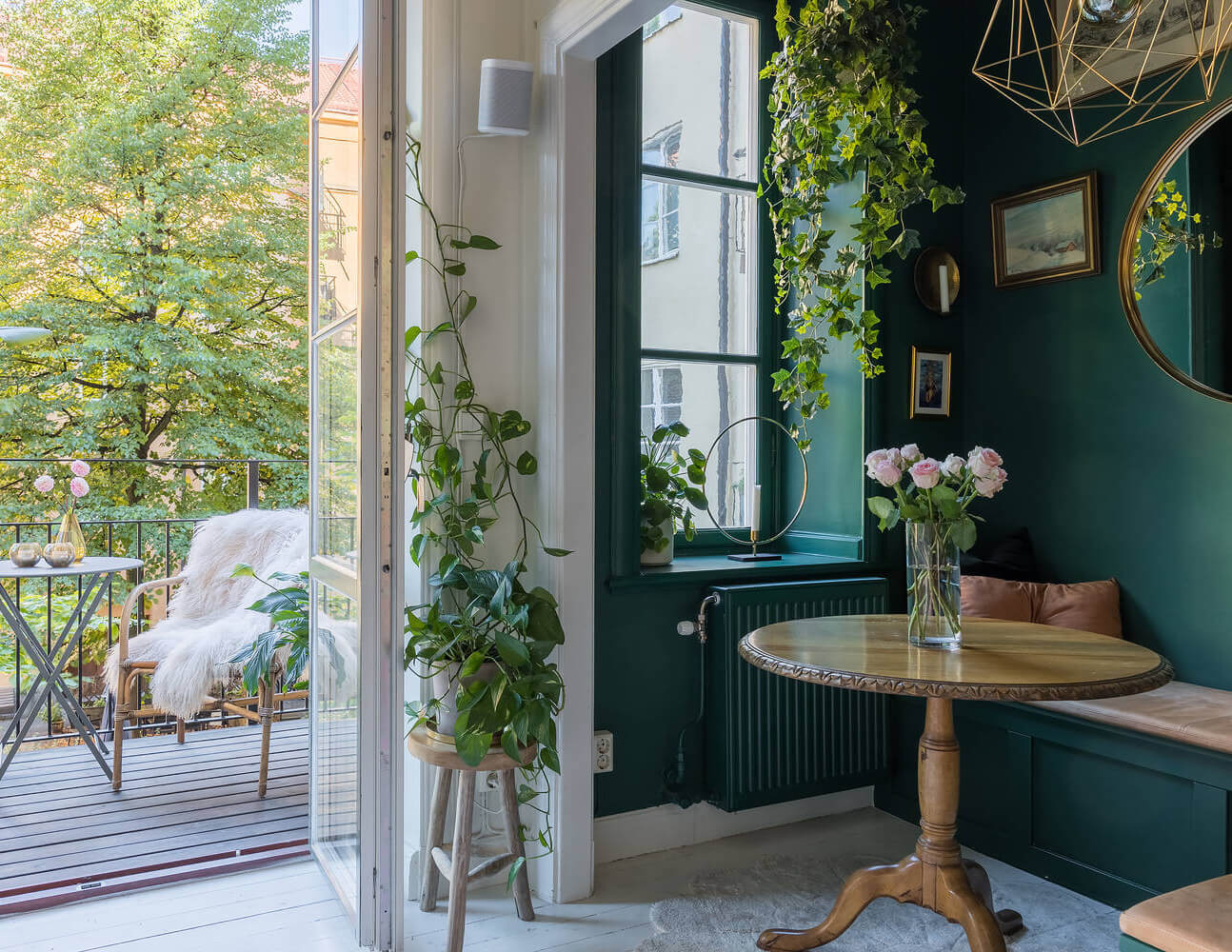 cozy breakfast nook with round wooden table and plants nordroom Behr Color of the Year 2026: Hidden Gem