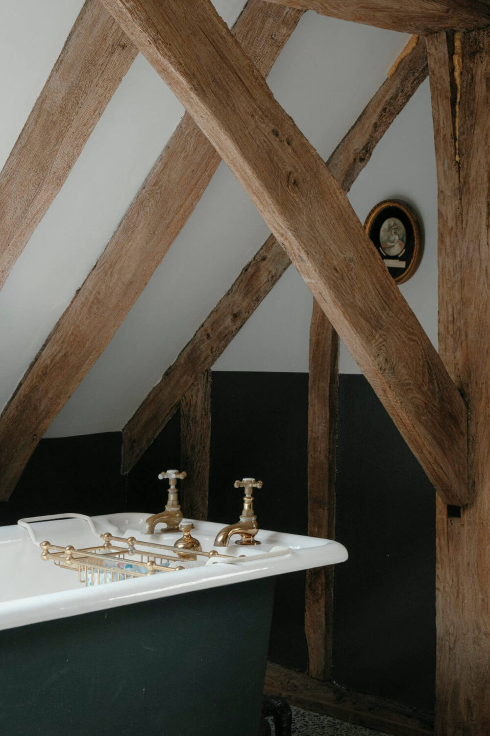 exposed wooden beams in bathroom with freestanding bath