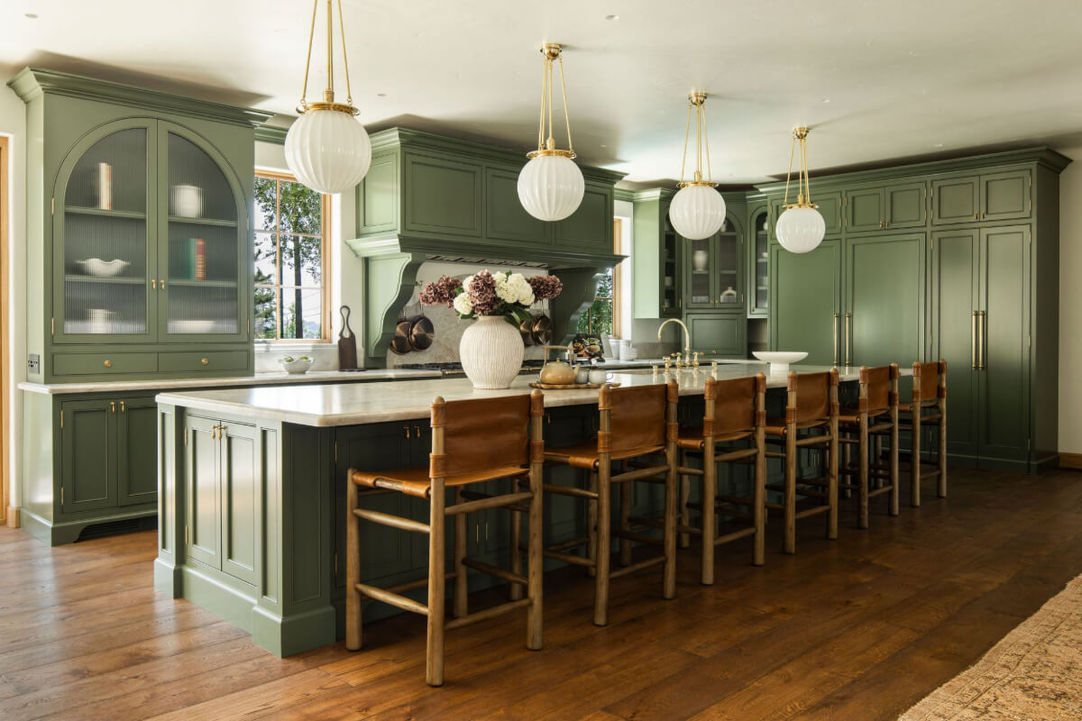 green kitchen with large island and stools