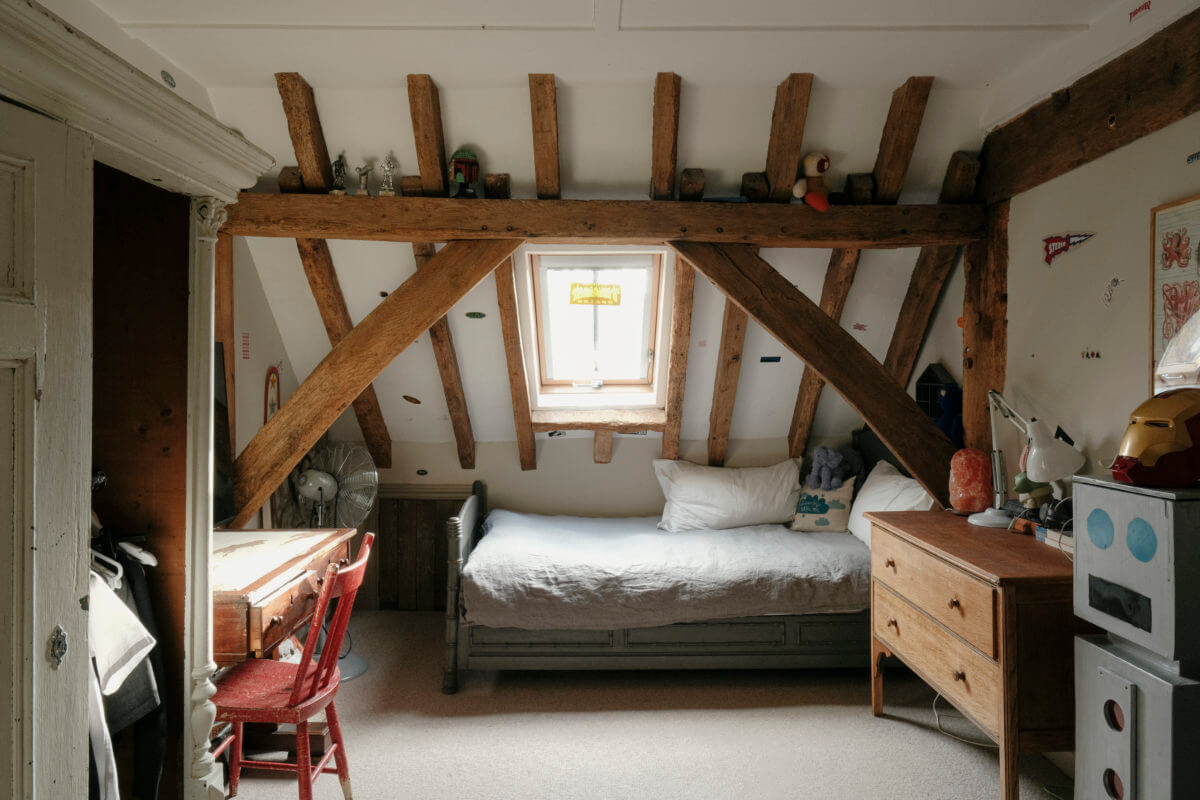 kids bedroom with slanted ceiling and wooden beams