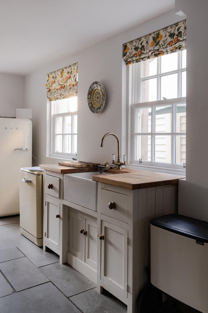 kitchen with stone floor white cabinets wooden worktop