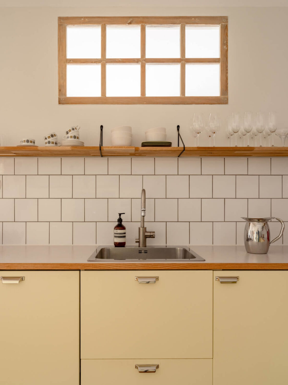 kitchen yellow cabinets white backsplash tiles shelf