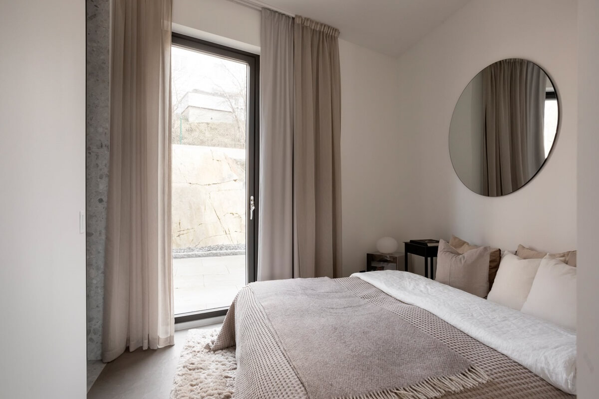 light colored bedroom with round mirror