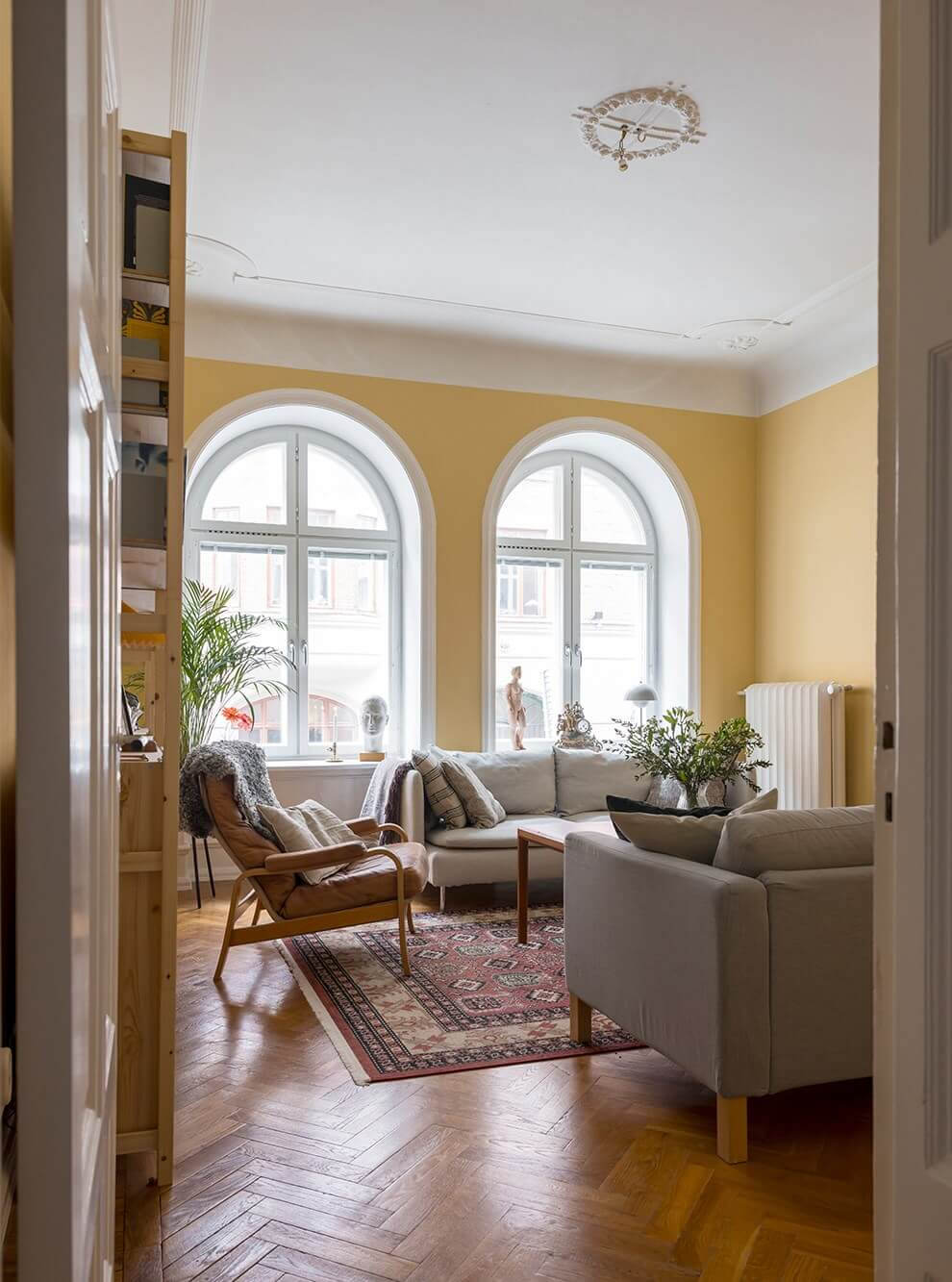 living room with yellow walls arched windows and parquet herringbone floor nordroom