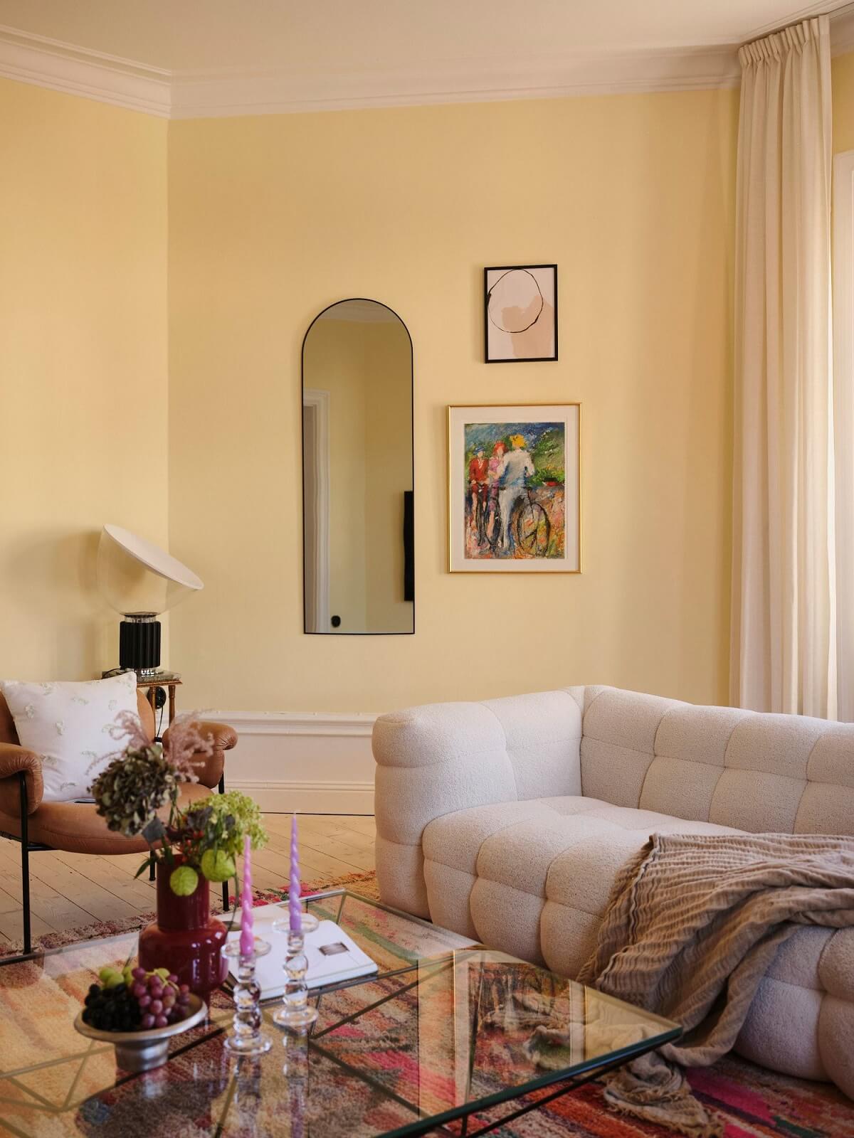 pastel yellow living room with arched niche nordroom