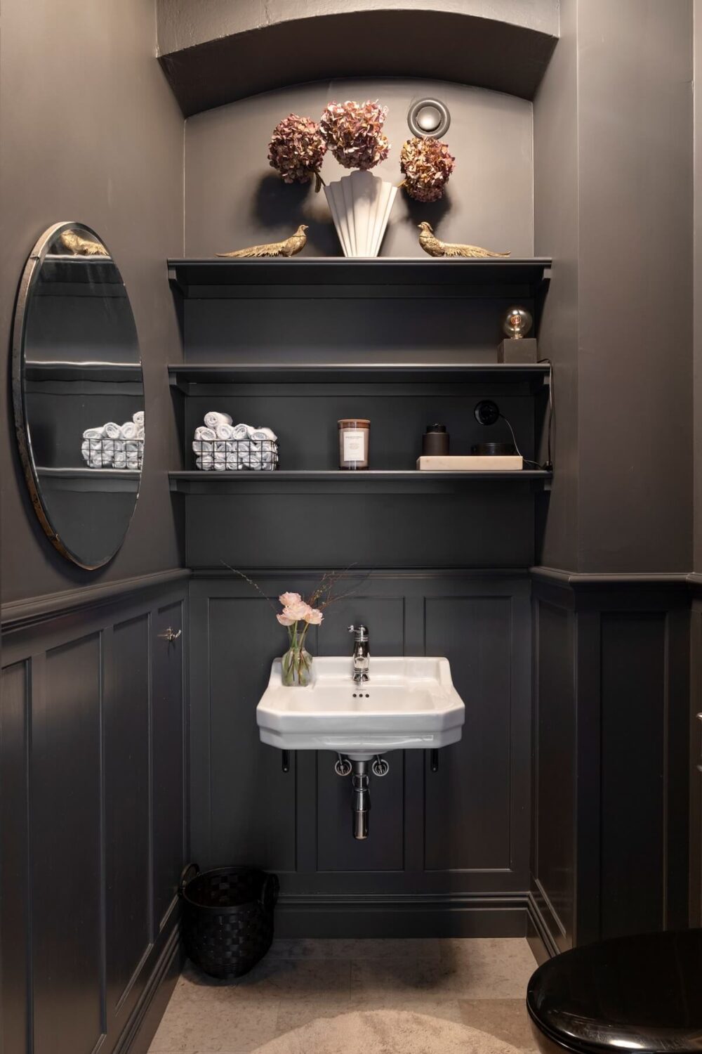 powder room with dark gray walls and shelves above the sink nordroom
