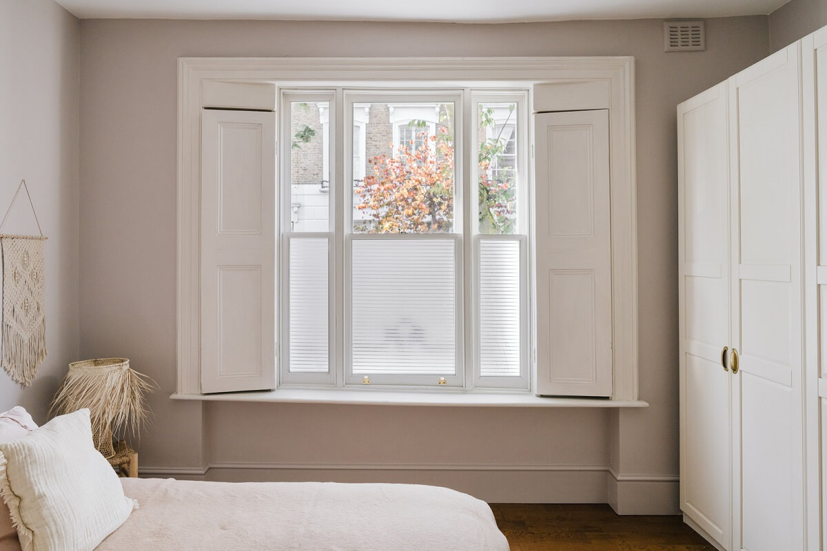 serene bedroom with shutters and wardrobes