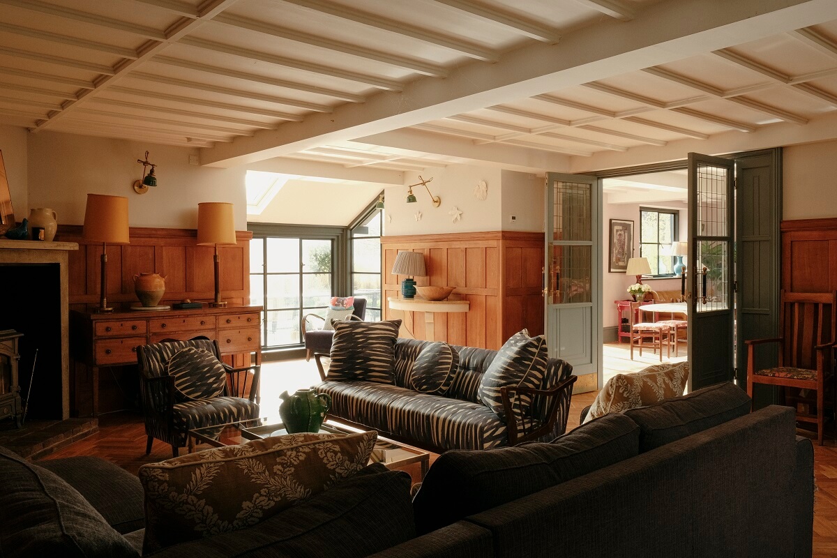 sitting room with low wooden ceiling and paneled walls