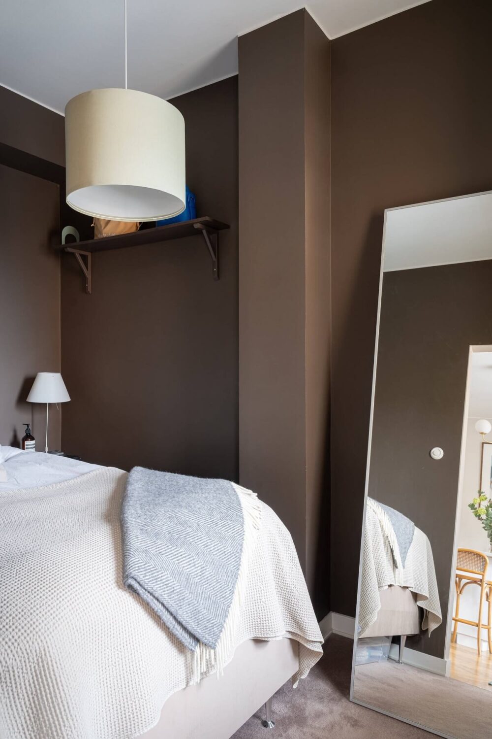 small bedroom with brown walls and large mirror nordroom