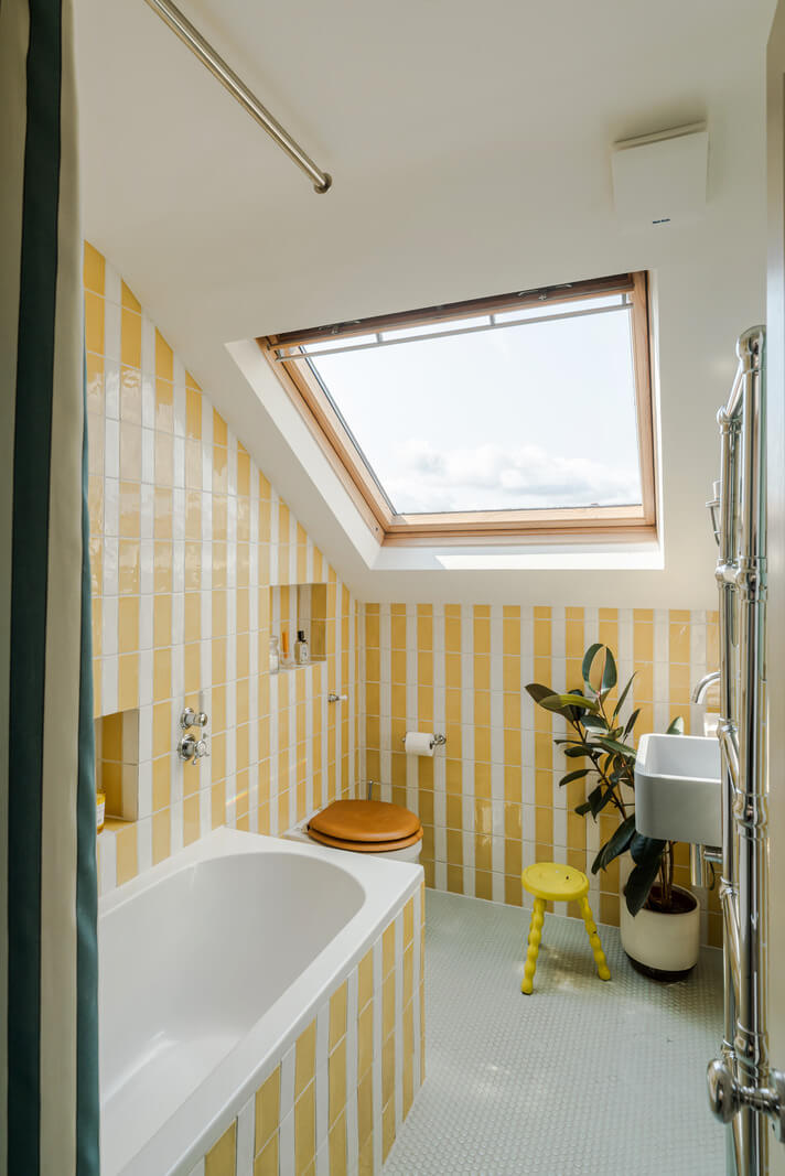 striped yellow tilework small bathroom slanted ceiling