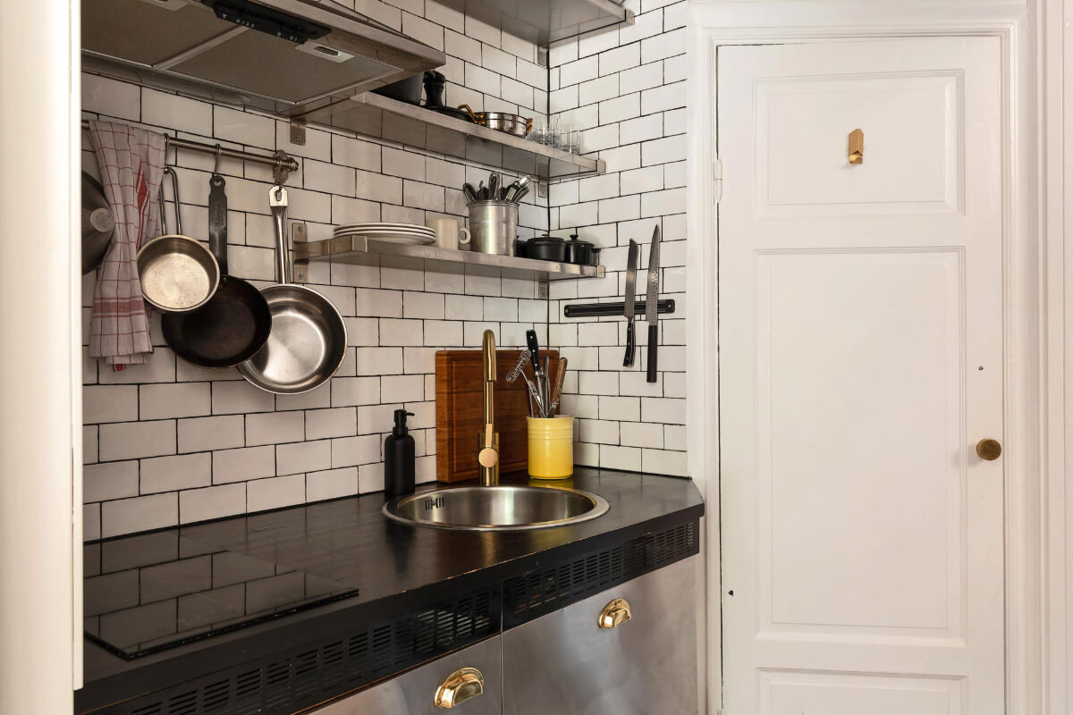 tiny kitchen white subway tiles stainless steel shelves