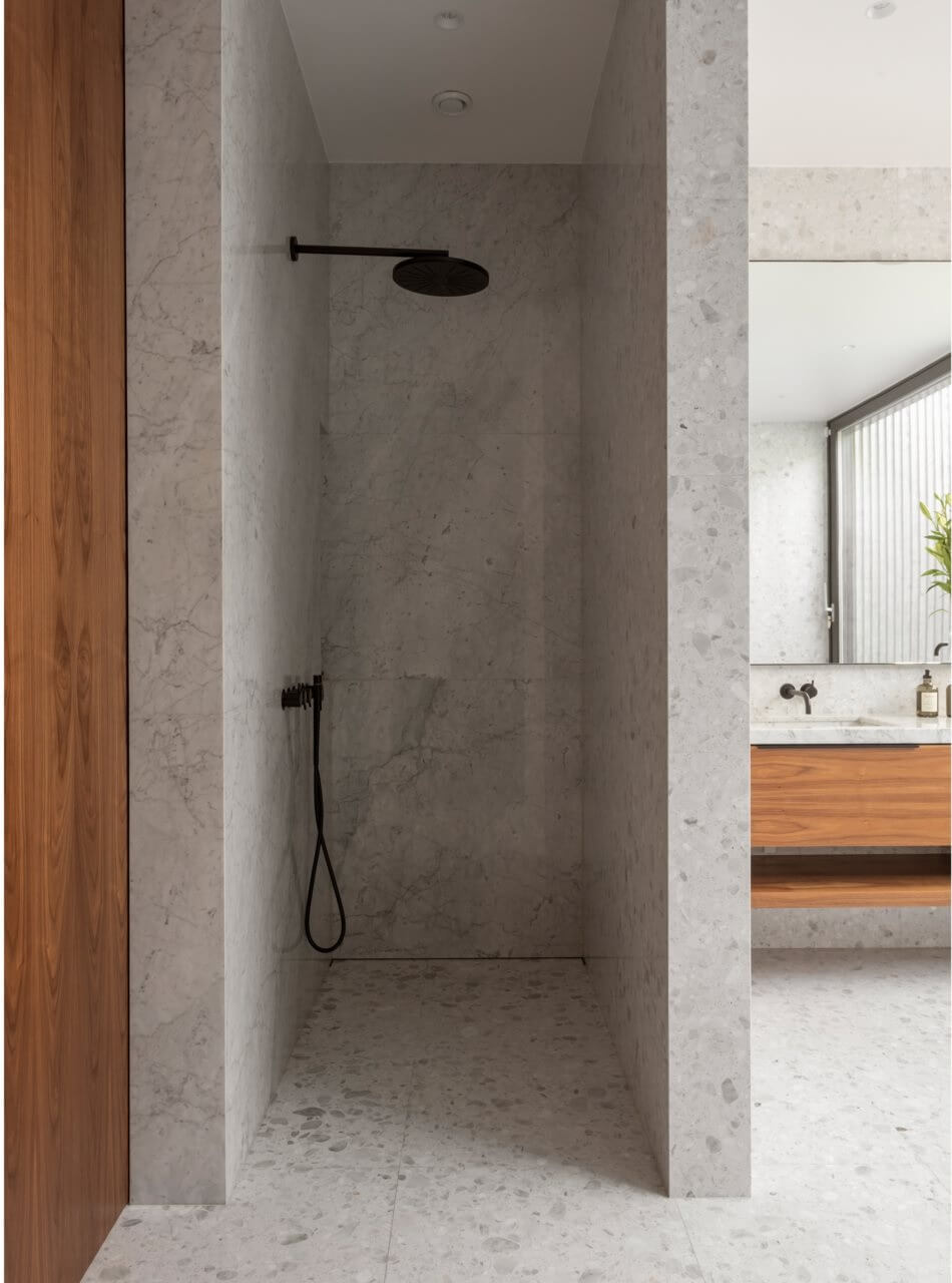 walk in shower with light gray tiles