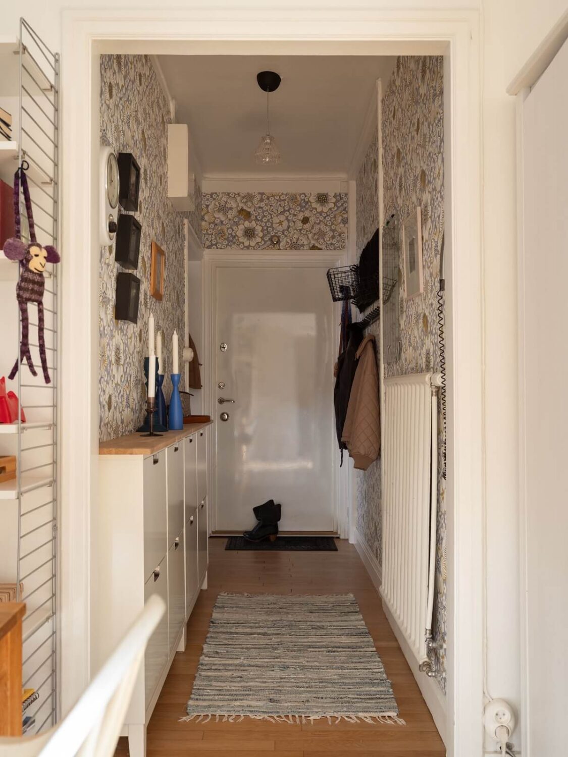 wallpapered hallway with shoe cabinets
